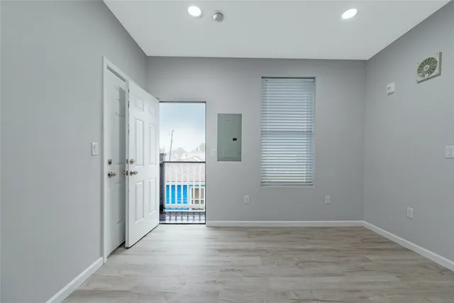 an empty room with wooden floor and windows
