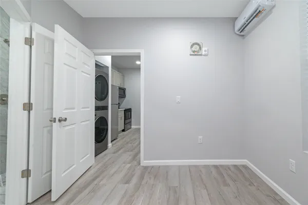 a view of a hallway with wooden floor and a bathroom