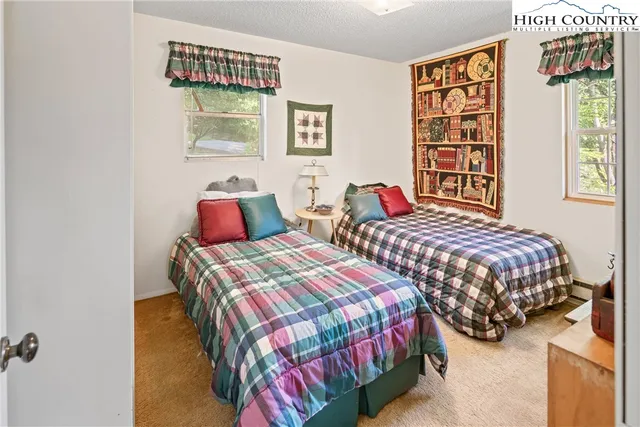 a bedroom with two beds and a painting on the wall