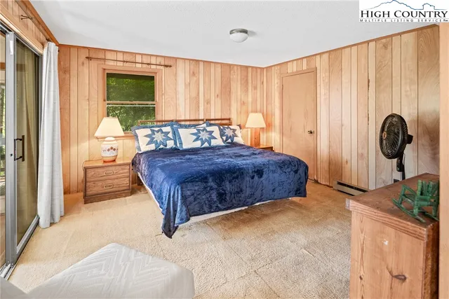 a bedroom with a bed and dresser with mirror