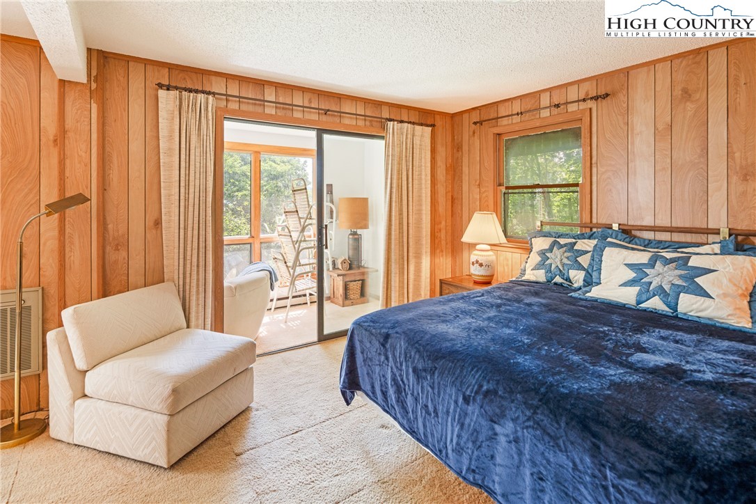 2811 Georges Gap Road Vilas, NC 28692 - Photo 20 of 50 a spacious bedroom with a large bed and a couch next to a window