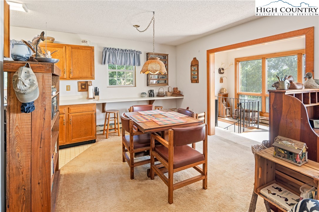 2811 Georges Gap Road Vilas, NC 28692 - Photo 9 of 50 a dining room with wooden floor a chandelier a wooden table and chairs