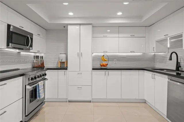 a kitchen with white cabinets and appliances