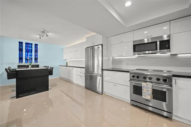 a kitchen with stainless steel appliances kitchen island granite countertop a stove and a refrigerator