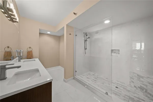 a bathroom with a sink a shower and a mirror