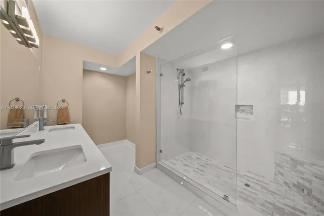 a bathroom with a sink a shower and a mirror