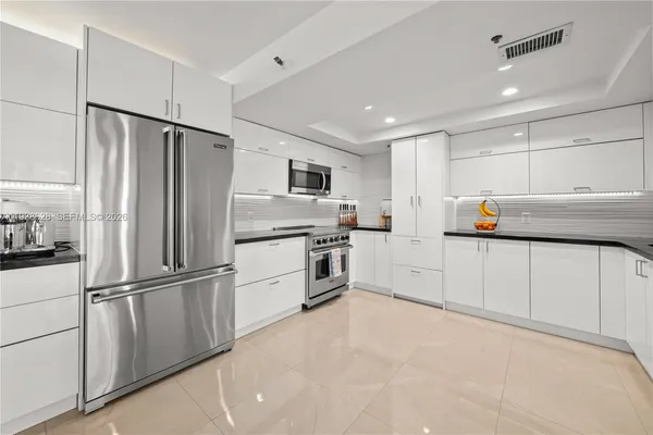 a kitchen with white cabinets and stainless steel appliances