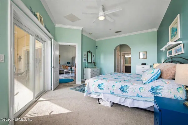 a bedroom with a bed mirror and a large window