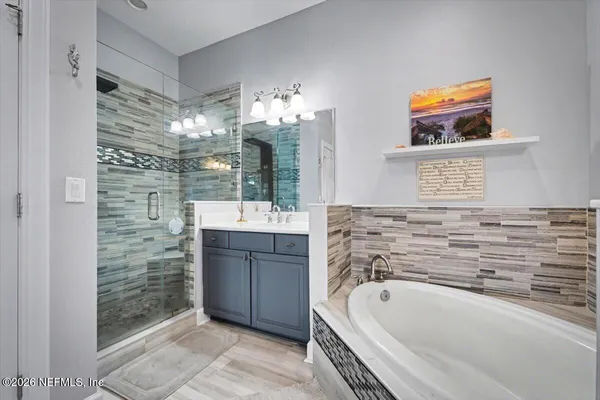 a bathroom with a tub a sink and a shower