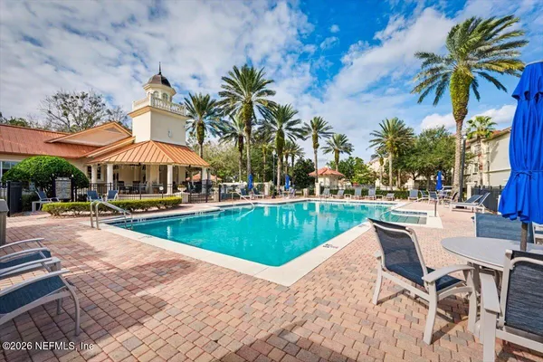 a view of a swimming pool with lawn chairs under an umbrella