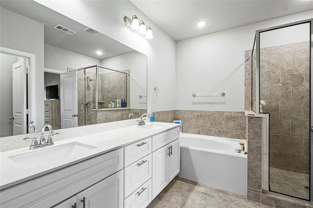 a bathroom with a double vanity sink mirror double and bathtub