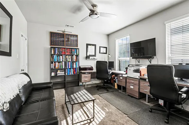 a view of a livingroom with workspace and a window