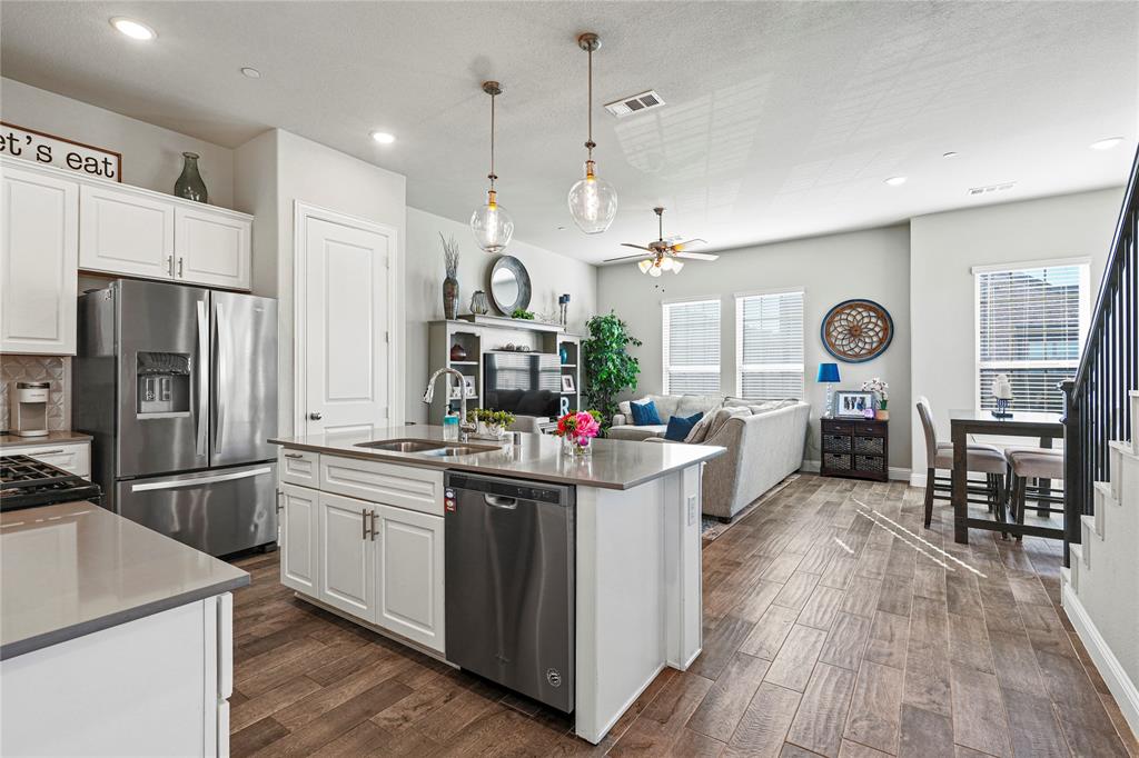 8010 Foraker Street Frisco, TX 75034 - Photo 5 of 13 a kitchen with stainless steel appliances kitchen island granite countertop a refrigerator a stove and a wooden floors