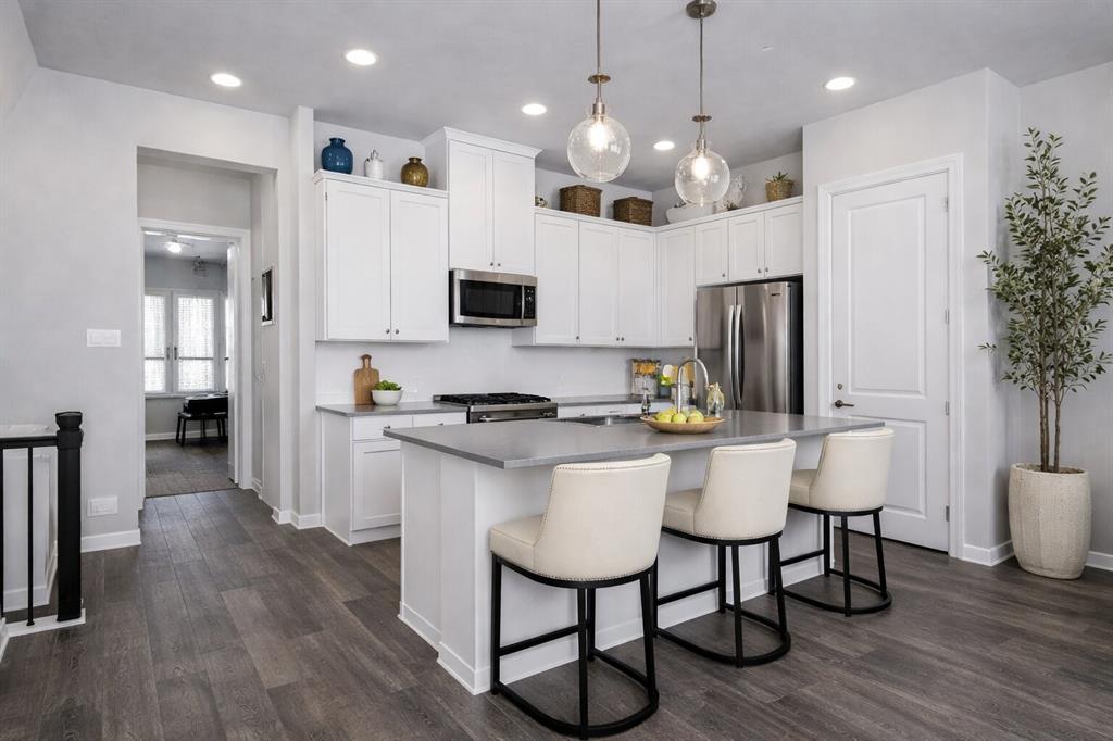 8010 Foraker Street Frisco, TX 75034 - Photo 6 of 17 a kitchen with stainless steel appliances a dining table chairs stove and refrigerator