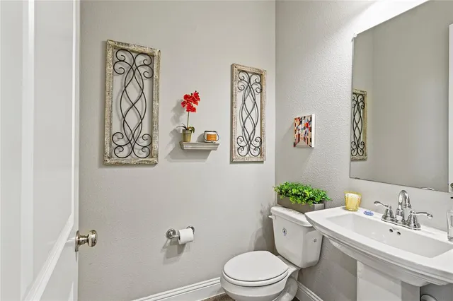 a bathroom with a toilet a sink and a mirror