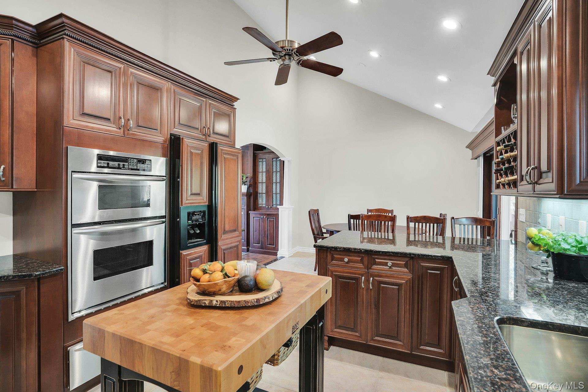 101 Hayrick Lane Commack, NY 11725 - Photo 18 of 50 a kitchen with stainless steel appliances kitchen island granite countertop a table chairs stove and refrigerator