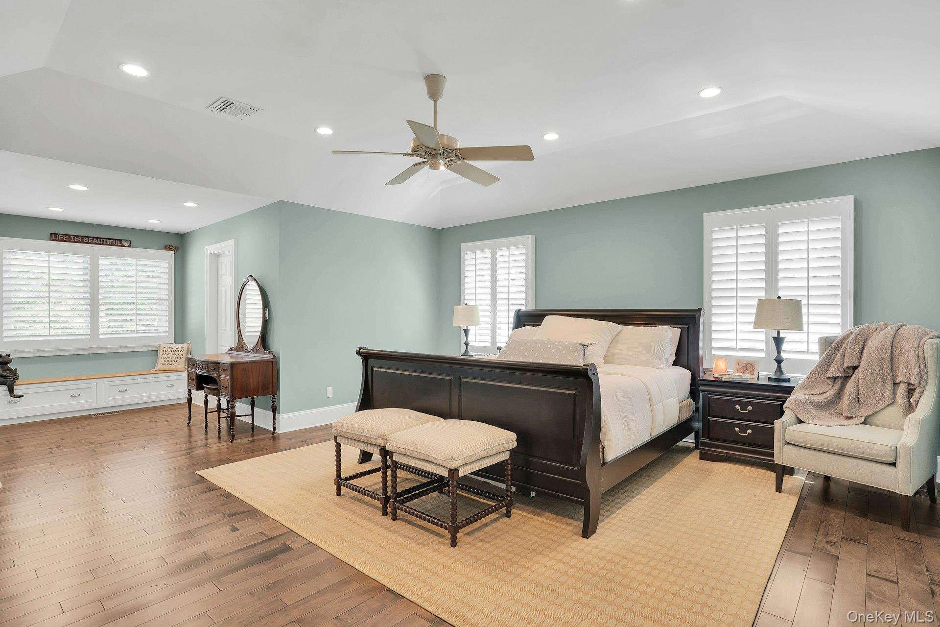 101 Hayrick Lane Commack, NY 11725 - Photo 22 of 50 a spacious bedroom with a bed a couch and a dresser with wooden floor