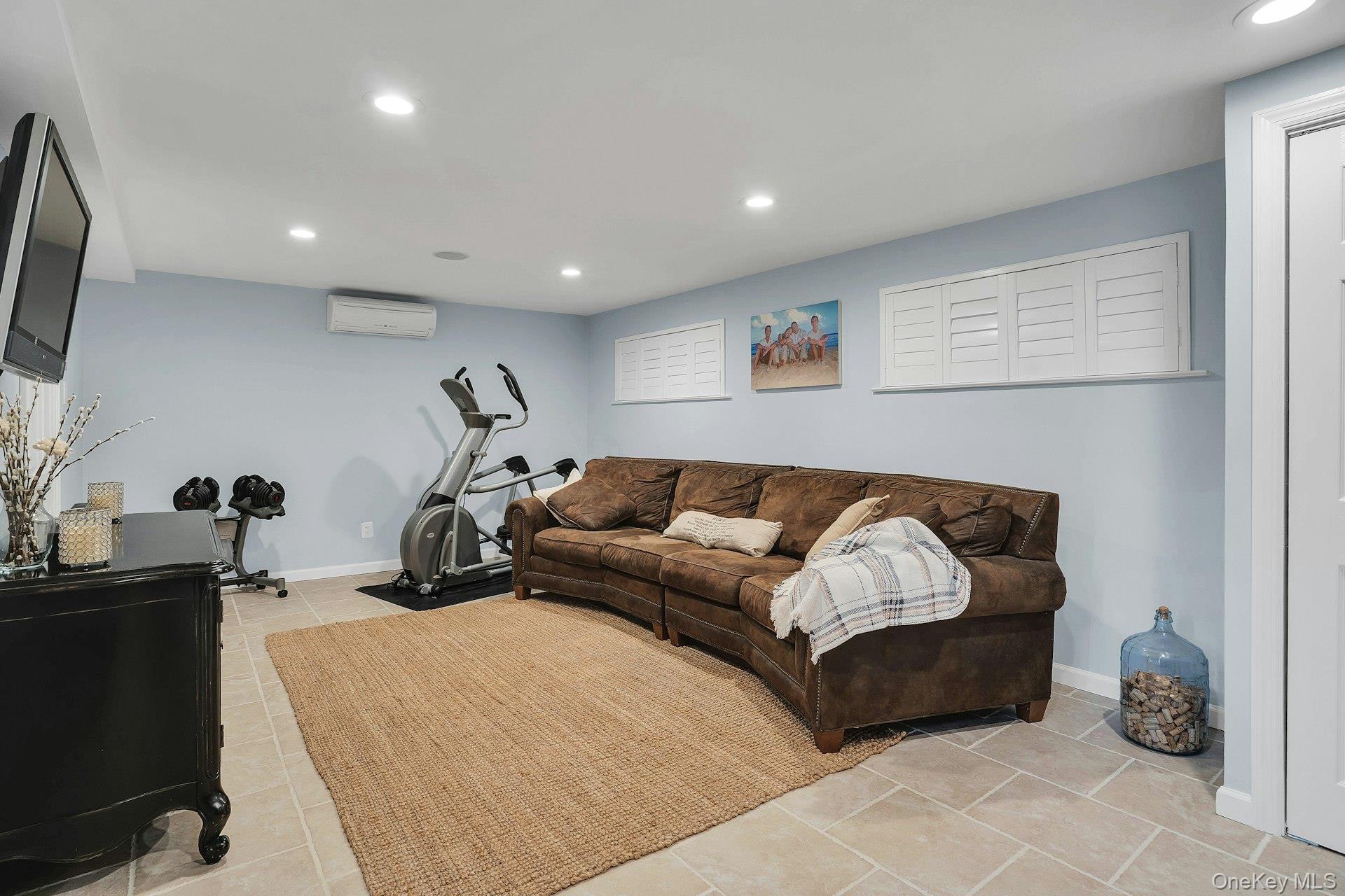 101 Hayrick Lane Commack, NY 11725 - Photo 29 of 50 a living room with furniture gym equipment and a flat screen tv