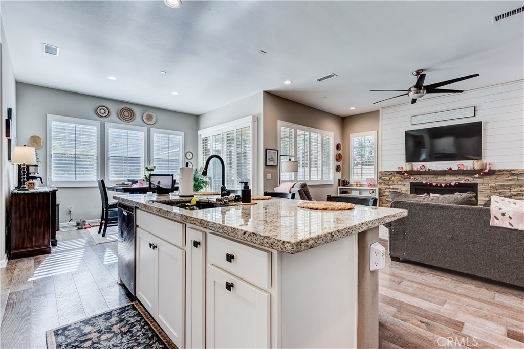 11137 Briar Rose Court Corona, CA 92883 - Photo 18 of 75 a large kitchen with granite countertop a sink and a stove top oven with wooden floor
