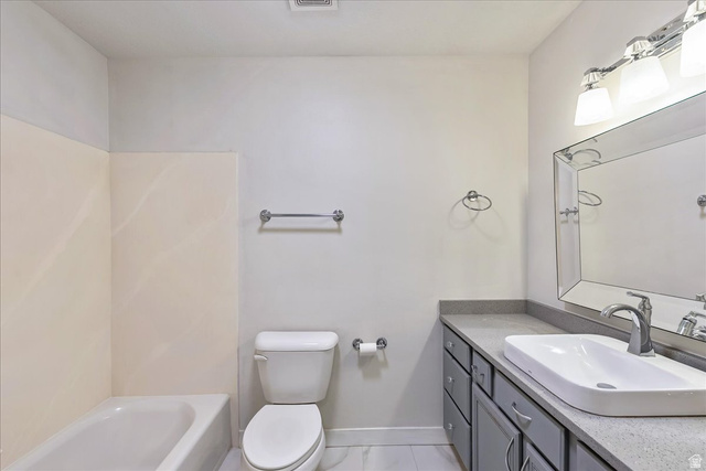 38 South 1000th Street East Payson, UT 84651 - Photo 15 of 19 Contemporary bathroom featuring a tub/shower combination with light-toned wall surround, a toilet, and a vanity with a surface-mount sink