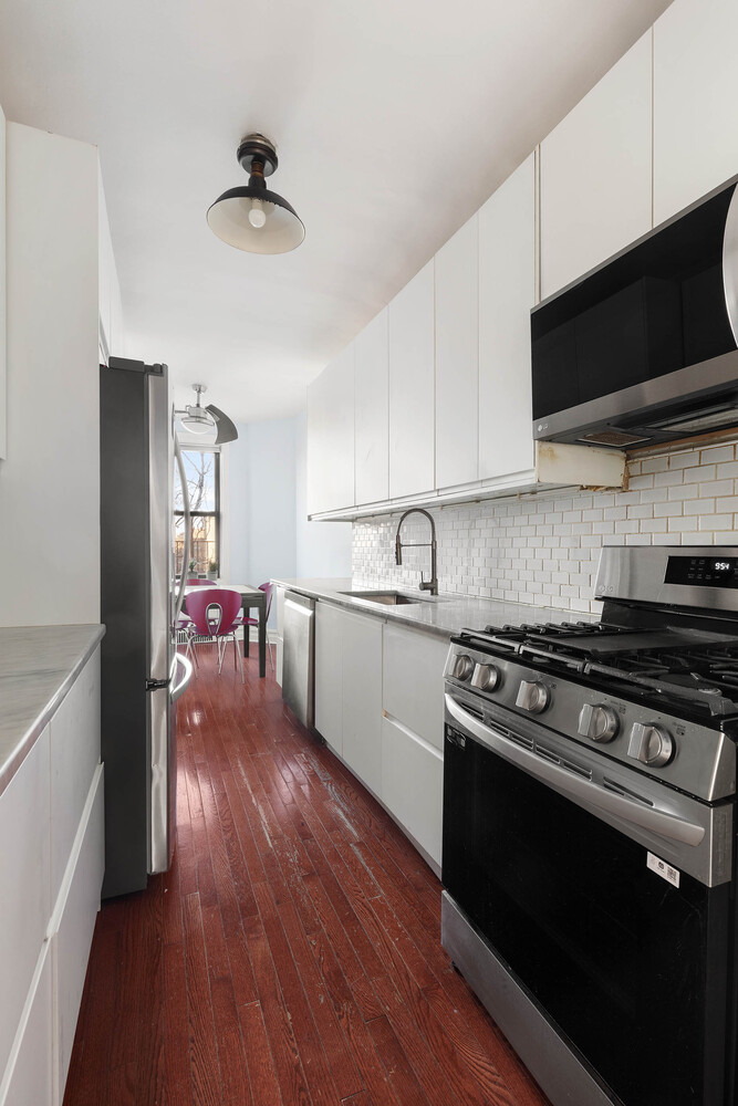 1701 Albemarle Road, Unit E8 Brooklyn, NY 11226 - Photo 5 of 9 a kitchen with stainless steel appliances a stove a microwave and cabinets