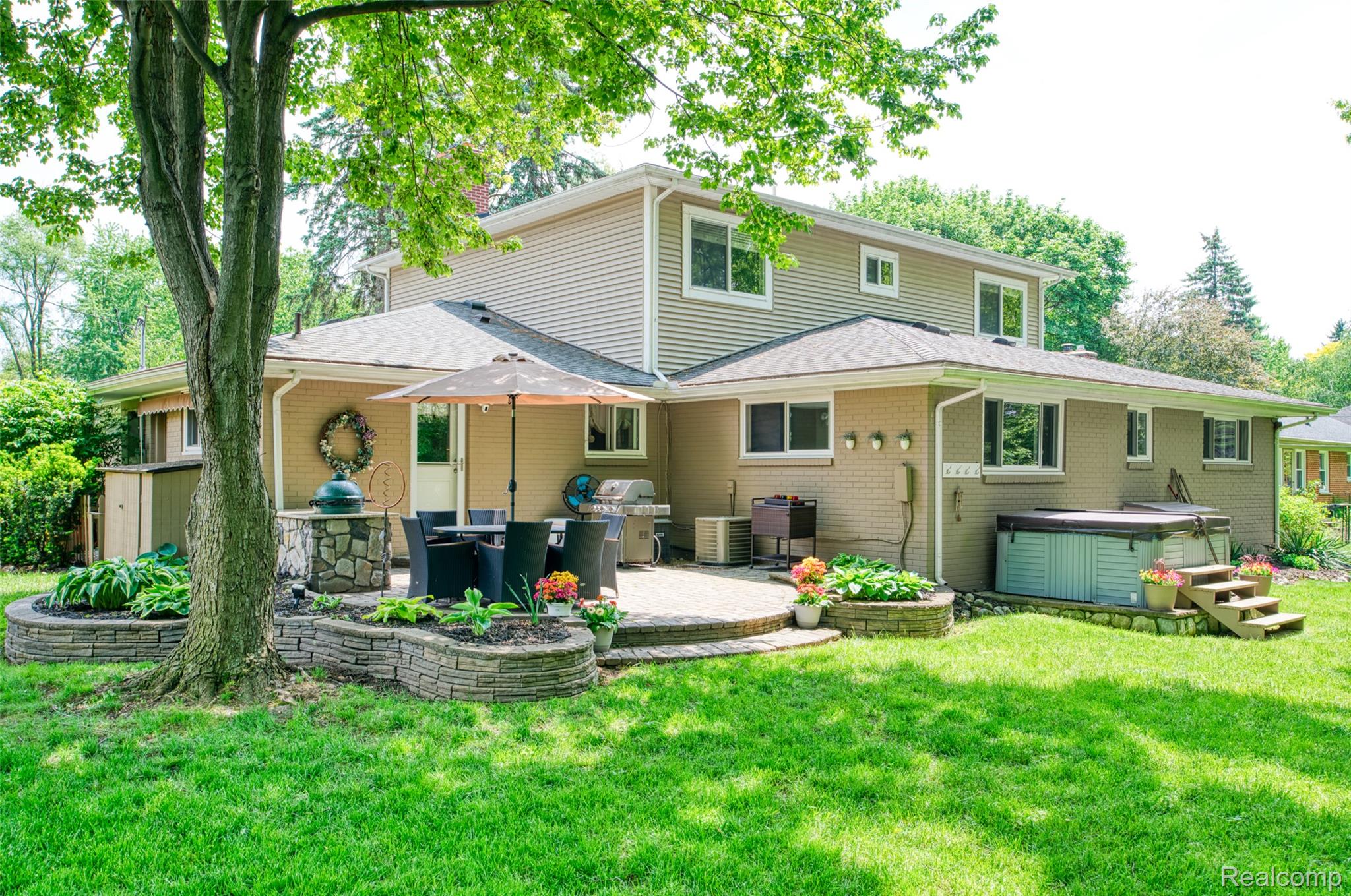 2172 Devonshire Road Bloomfield Hills, MI 48302 - Photo 34 of 45 Spacious backyard featuring a paver patio, stone-faced built-in planters, and a hot tub