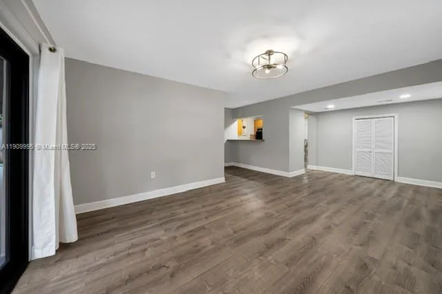 a view of empty room with wooden floor