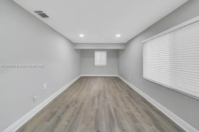 a view of a room with wooden floor and window