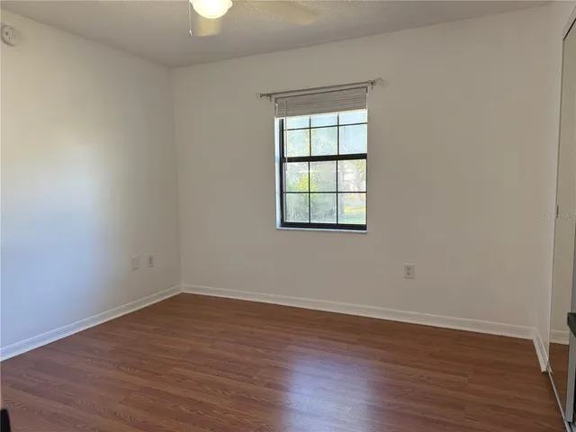 an empty room with wooden floor and a window