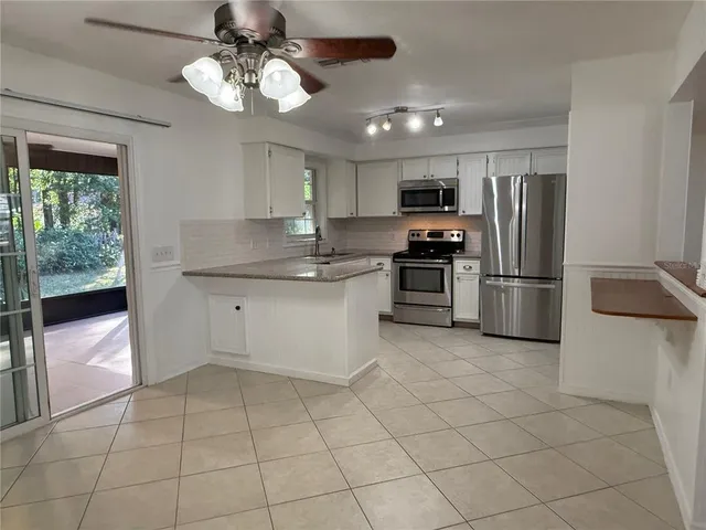 a kitchen with stainless steel appliances granite countertop a refrigerator and a sink