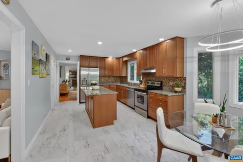 a kitchen with stainless steel appliances granite countertop a refrigerator a stove top oven and a sink with granite countertops