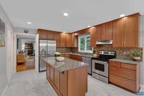 a kitchen with stainless steel appliances granite countertop wooden cabinets a sink and a stove