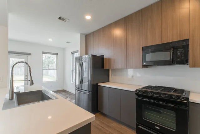 a kitchen with stainless steel appliances a stove microwave and sink
