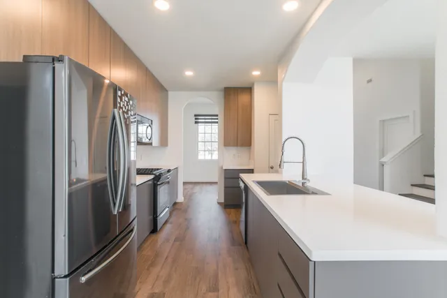 a kitchen with stainless steel appliances a sink stove and refrigerator