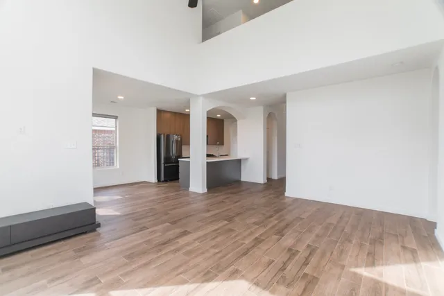an empty room with wooden floor and a window