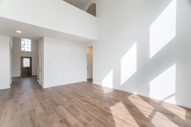 a view of a hallway with wooden floor and staircase