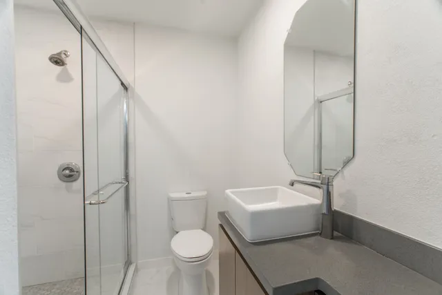 a bathroom with a sink toilet and shower
