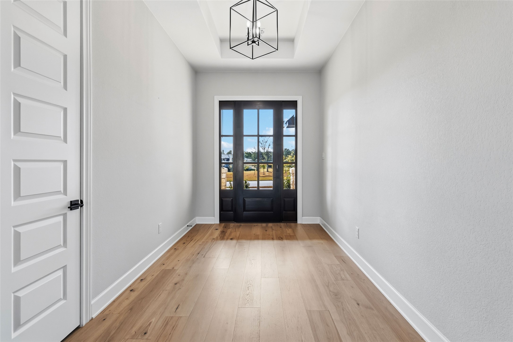 640 Prairie Clover Drive Dripping Springs, TX 78620 - Photo 2 of 32 Doorway featuring wood-type flooring and a chandelier