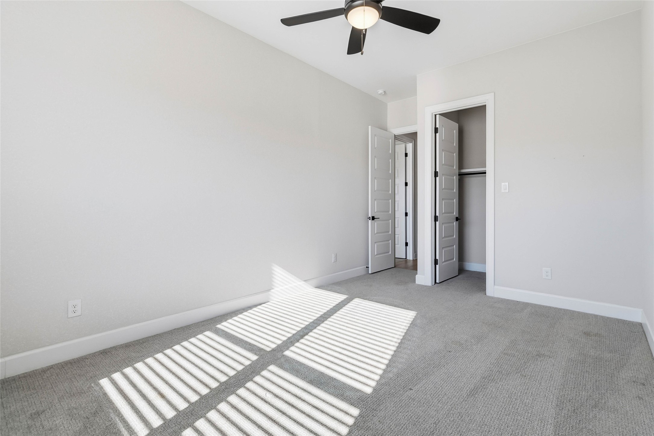 640 Prairie Clover Drive Dripping Springs, TX 78620 - Photo 25 of 32 Unfurnished bedroom with a ceiling fan, light carpet, and a closet