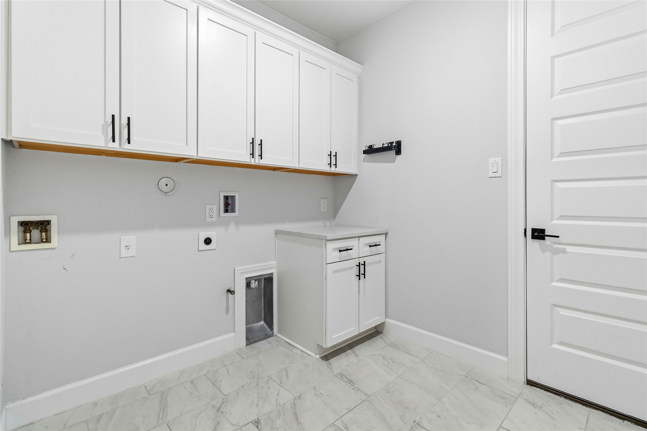 640 Prairie Clover Drive Dripping Springs, TX 78620 - Photo 26 of 32 Washroom featuring hookup for a gas dryer, washer hookup, light marble finish floors, hookup for an electric dryer, and cabinet space