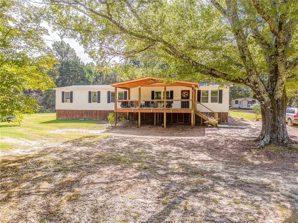 1039 Old Cedartown Road Rockmart, GA 30153 - Photo 1 of 40 a front view of a house with a garden and trees