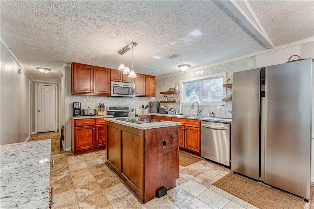 1039 Old Cedartown Road Rockmart, GA 30153 - Photo 20 of 40 a large kitchen with stainless steel appliances granite countertop a stove refrigerator a sink dishwasher a oven and a refrigerator