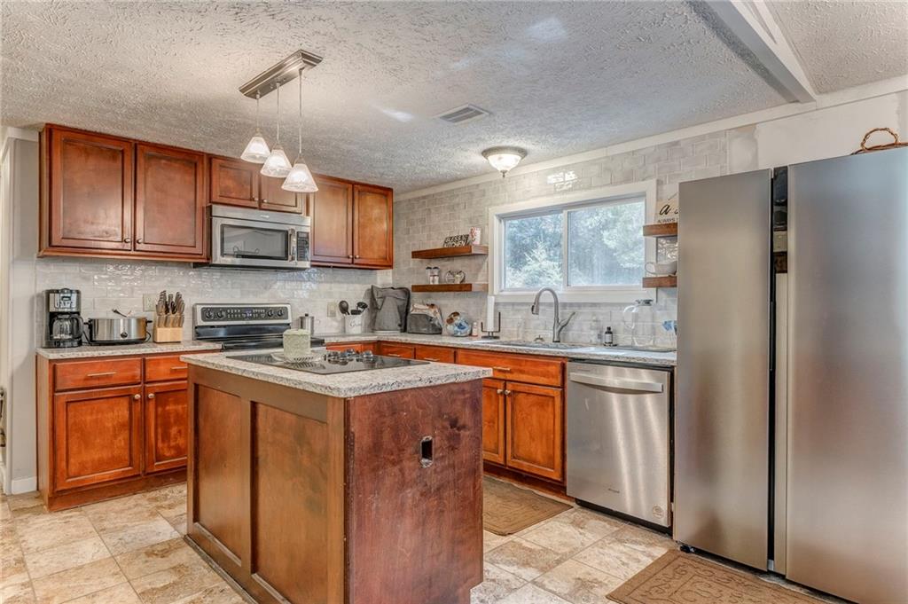 1039 Old Cedartown Road Rockmart, GA 30153 - Photo 21 of 40 a kitchen with stainless steel appliances granite countertop a stove top oven a sink dishwasher and a refrigerator