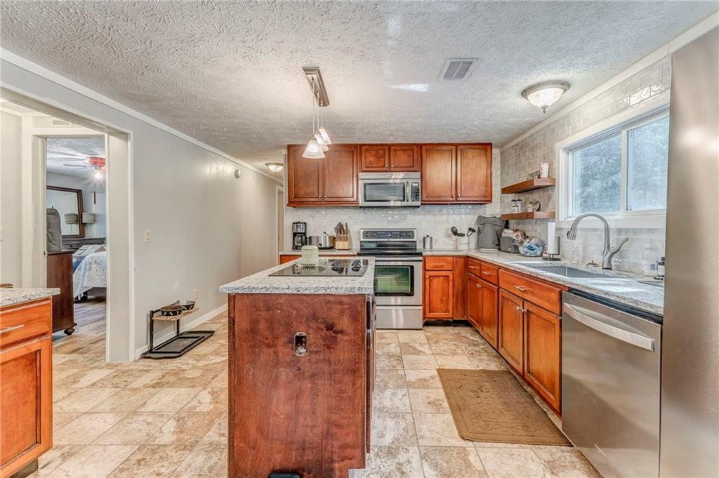 1039 Old Cedartown Road Rockmart, GA 30153 - Photo 22 of 40 a kitchen with stainless steel appliances granite countertop a sink stove and refrigerator