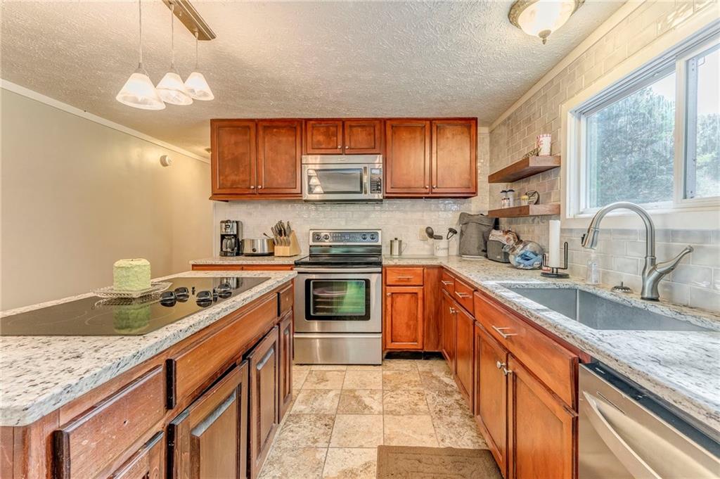 1039 Old Cedartown Road Rockmart, GA 30153 - Photo 23 of 40 a kitchen with stainless steel appliances granite countertop a sink stove and refrigerator
