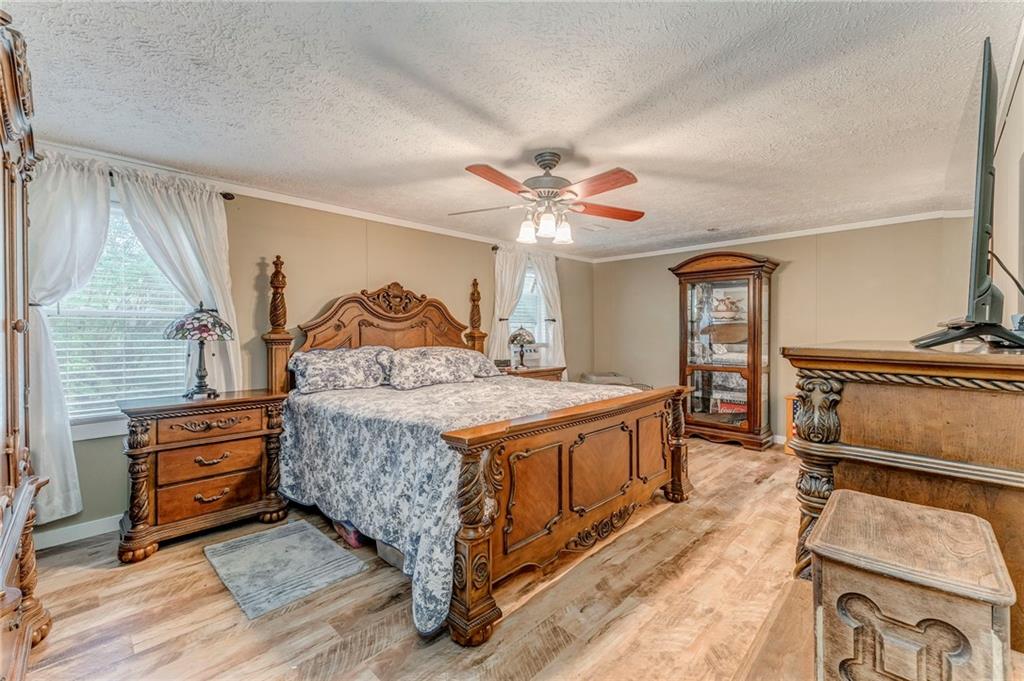 1039 Old Cedartown Road Rockmart, GA 30153 - Photo 27 of 40 a spacious bedroom with a bed and a chandelier