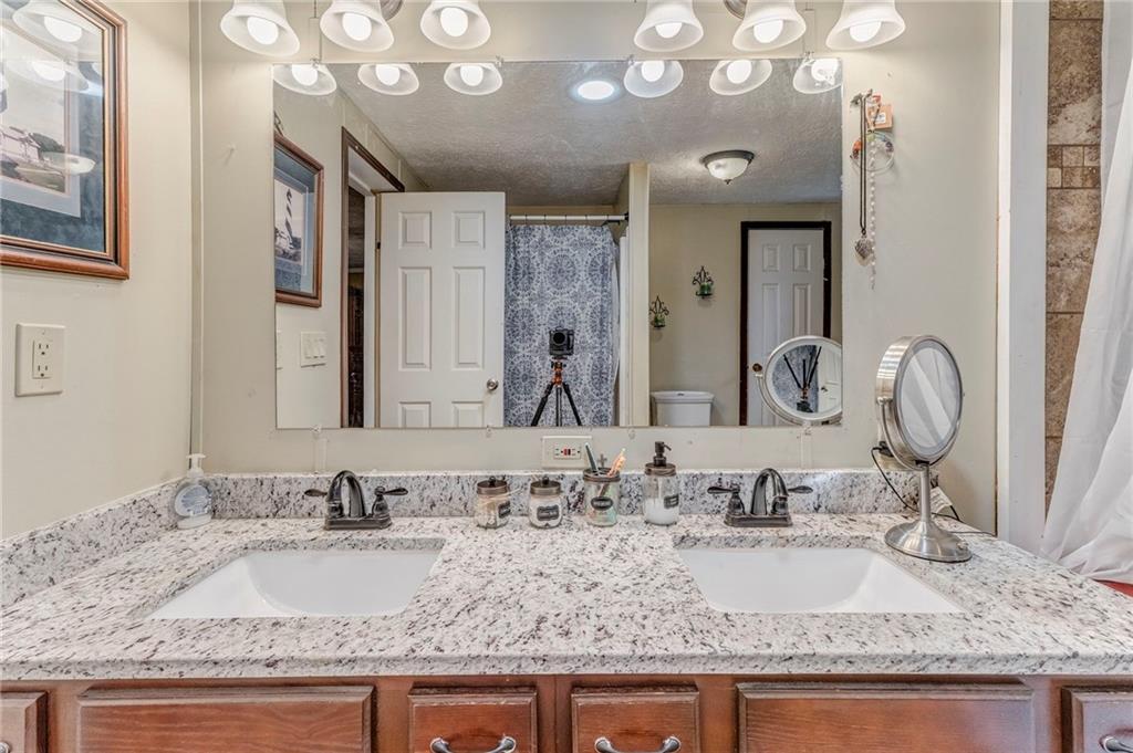 1039 Old Cedartown Road Rockmart, GA 30153 - Photo 30 of 40 a bathroom with a granite countertop double vanity sinks and a mirror