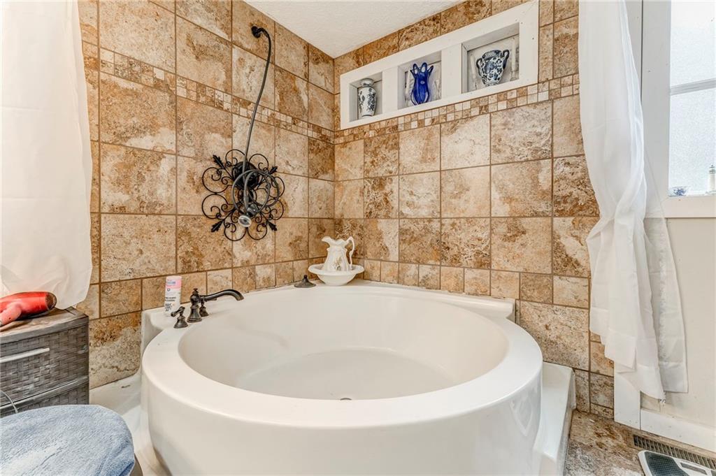 1039 Old Cedartown Road Rockmart, GA 30153 - Photo 32 of 40 a white bath tub sitting in a bathroom