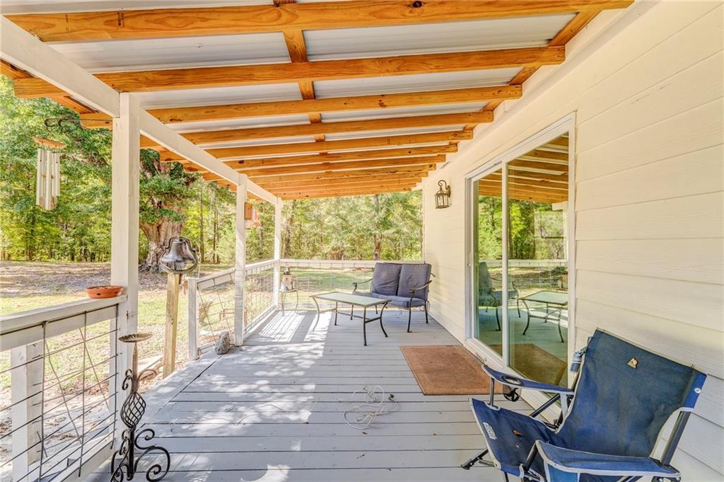 1039 Old Cedartown Road Rockmart, GA 30153 - Photo 39 of 40 a view of a patio with couches chairs and wooden floor