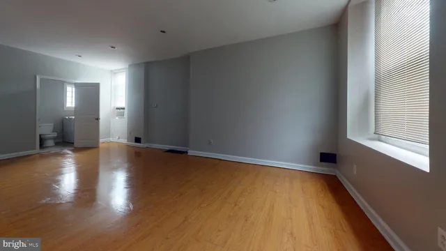 a view of a room with wooden floor and window